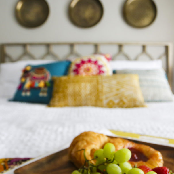 Pastry and grapes on tray by bed.
