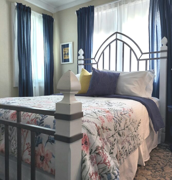 A bed room with a white and blue bedspread