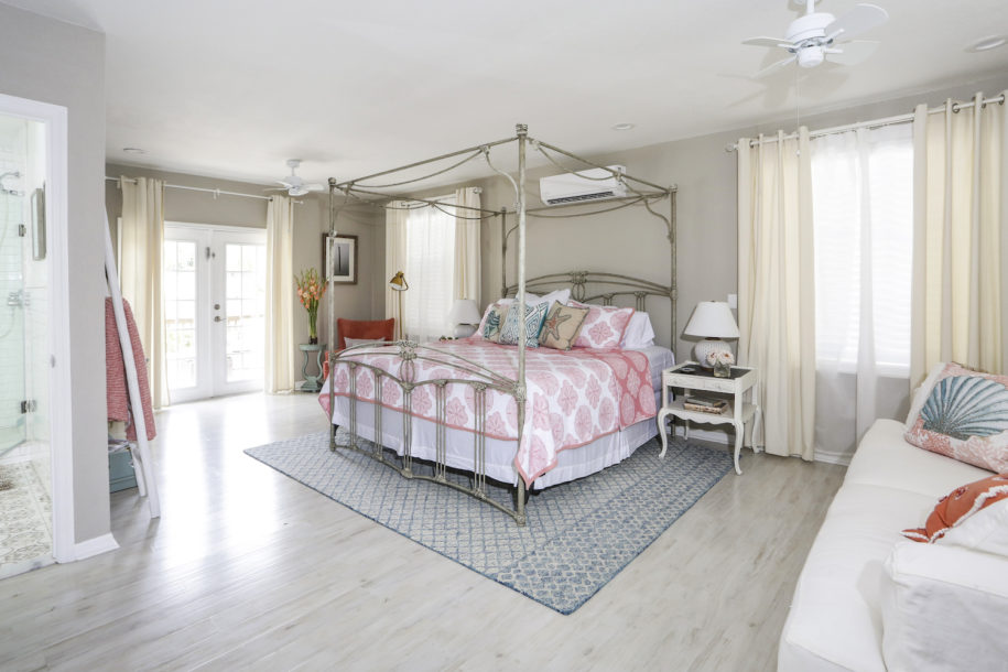 A bedroom with a bed, dresser and window.