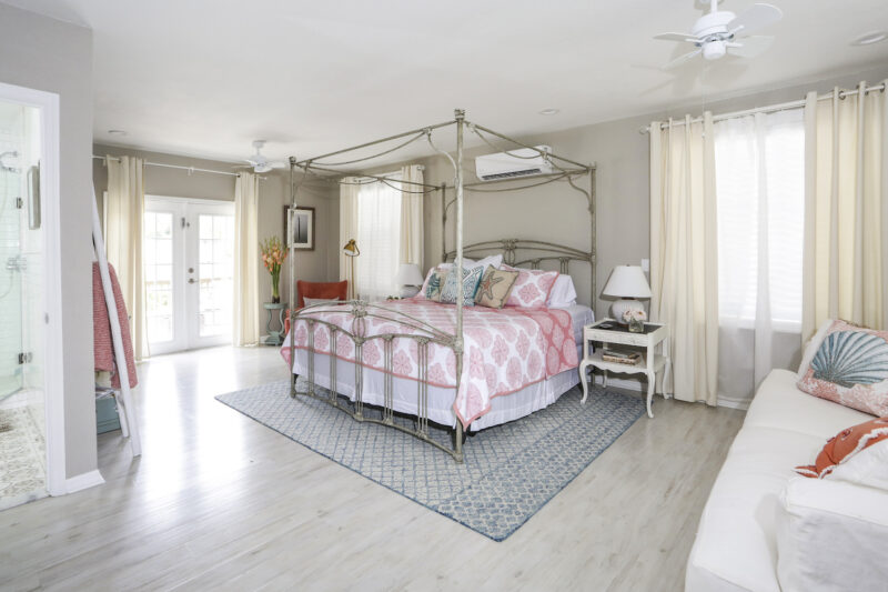 A bedroom with a bed, dresser and window.